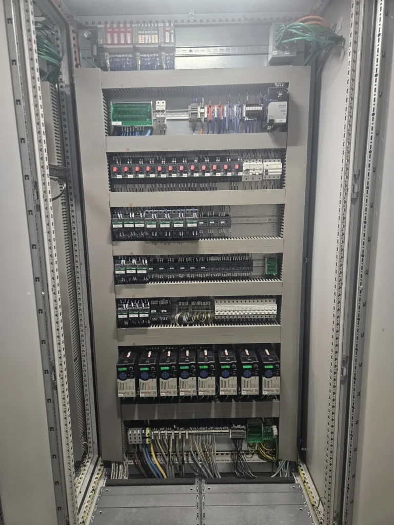 Wnętrze szafy sterowniczej: instalacja falownika (serwonapędu) oraz zabezpieczeń elektrycznych. Integracja systemów napędowych w automatyce maszyn.